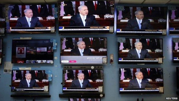 Israel's Prime Minister Benjamin Netanyahu is seen delivering his speech to the U.S. Congress on television screens in an electronics store in a Jerusalem shopping mall 3 March 2015