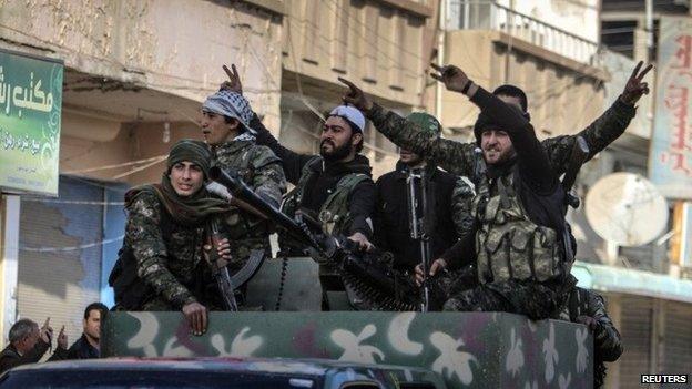 Fighters from the Kurdish People's Protection Units on the back of a vehicle