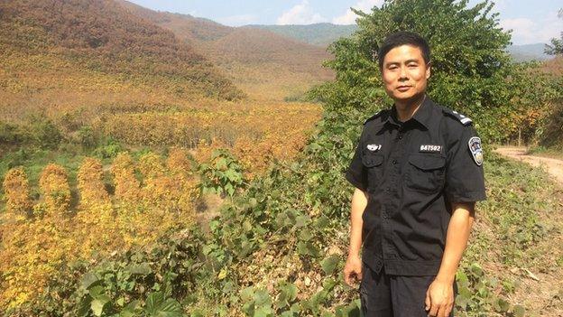 Mr Chang next to a rubber plantation