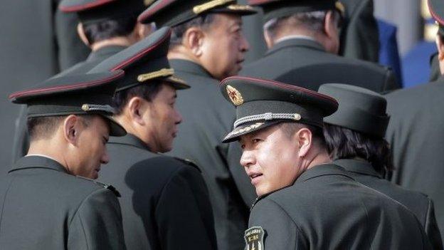 A military officer (R) from the Second Artillery Force of Chinese People's Liberation Army (PLA) and other delegates arrive at the Great Hall of the People for the annual session of China"s parliament, the National People"s Congress, in Beijing, 4 March 2015