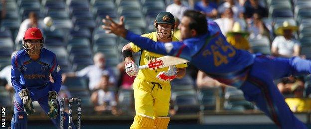 Afghanistan bowler Samiullah Shinwari dives for the ball off Australian batsman David Warner