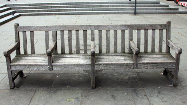 A bench with arm rests dividing it to stop people sleeping