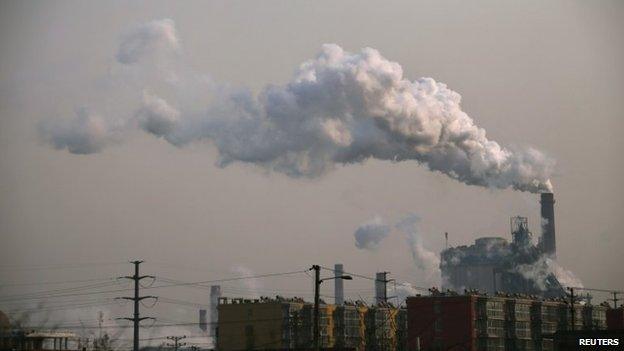 Smoke rises from a chimney of a steel plant next to residential buildings on a hazy day in Fengnan district of Tangshan, Hebei province in this 18 February 2014 file picture