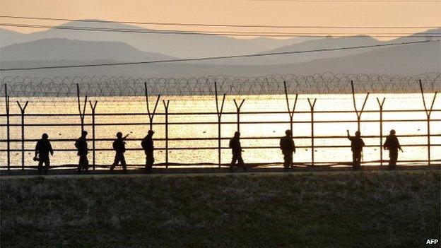 South Korean soldiers patrol along a military fence near the Demilitarized Zone (DMZ) dividing the two Koreas in the border city of Paju on April 26, 2013.