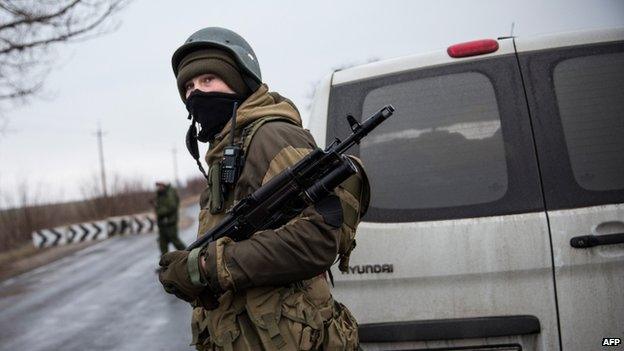 A pro-Russian separatist stands guard at a checkpoint on the road heading to Mariupol on 4 March 2015 in Ukraine