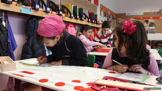 Schoolgirls write during a lesson at the private TUEDESB (a Turkish-German education institute) primary school in Berlin, Germany on 14 April 2010