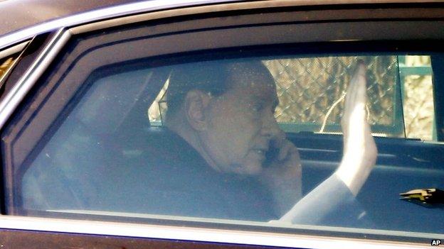 Italy's former PM Silvio Berlusconi on a mobile phone as he leaves the Sacra Famiglia institute in Cesano Boscone, near Milan 06/03/2015