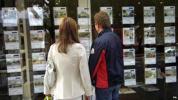 Couple look at estate agents window