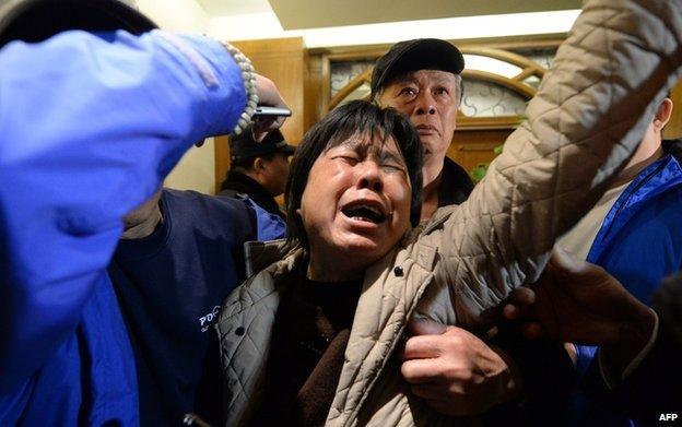 Relatives of passengers on Malaysia Airlines flight MH370 react to the news that the plane plunged into Indian Ocean at a hotel in Beijing on March 24, 2014