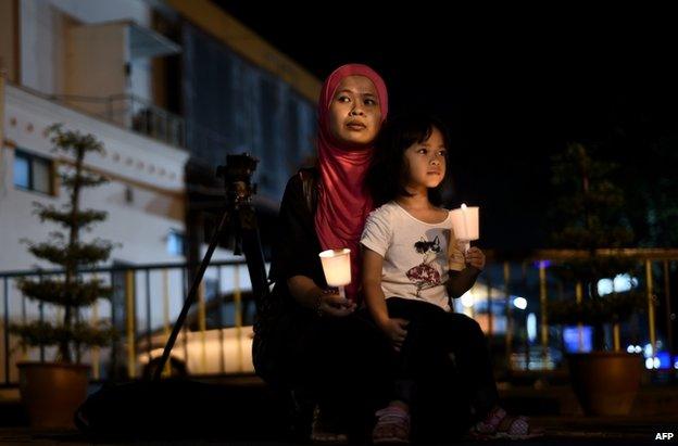 A young Malaysian girl sits in her mother's lap during a gathering to mark the one-year anniversary of the disappearance of Malaysia Airlines flight MH370, in Kuala Lumpur, 6 March