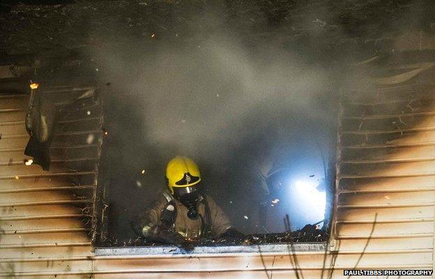 Firefighter in upstairs window of Winston Churchill Drive property