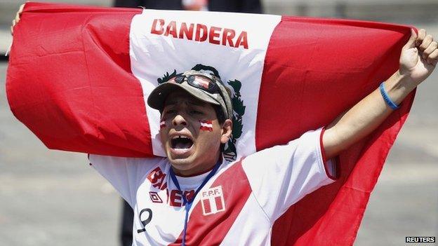 A supporter holds a Peruvian flag after knowing the final ruling court decision of a decades-old maritime dispute between Peru and Chile, at the Government Palace in Lima