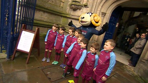 Rammie and young footballers outside Derby Cathedral