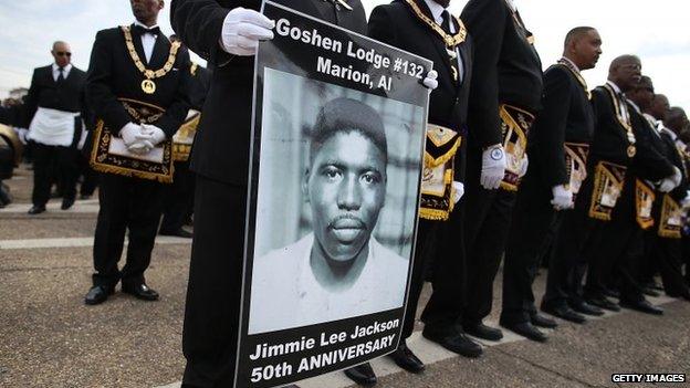 A marcher holds a poster of Jimmie Lee Jackson, a civil rights activist who was beaten and shot by Alabama State troopers in 1965