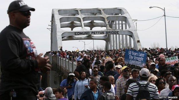 Thousands of people walk across the Edmund Pettus Bridge during the 50th anniversary commemoration of the Selma to Montgomery civil rights march on March 8, 2015 in Selma, Alabama