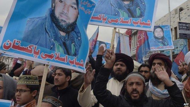 Pakistani Islamist and supporters of former police bodyguard Mumtaz Qadri, hold his portrait as they shout slogans calling for his release during a protest outside the high court building in Islamabad on 3 February 2015.