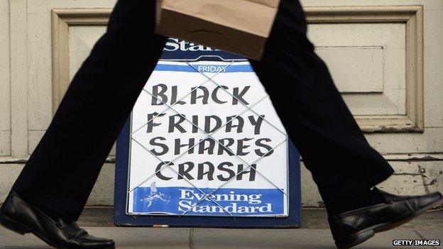 A city worker passes a headline board showing the words 'Black Friday Shares Crash' on October 10, 2008