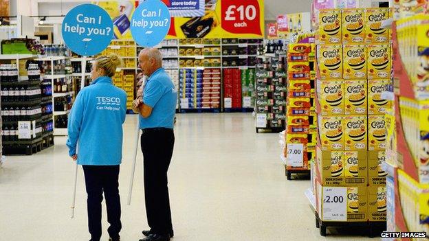 Tesco workers stand in supermarket