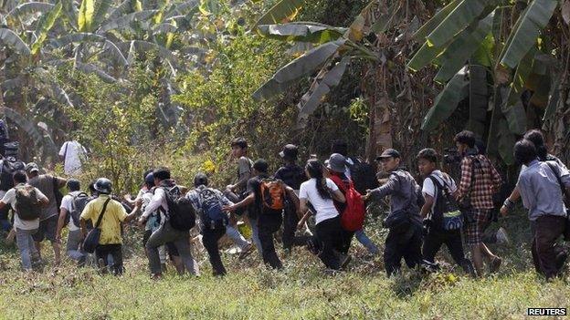 Reporters run to a safe place during violence in Letpadan 10 March 2015.