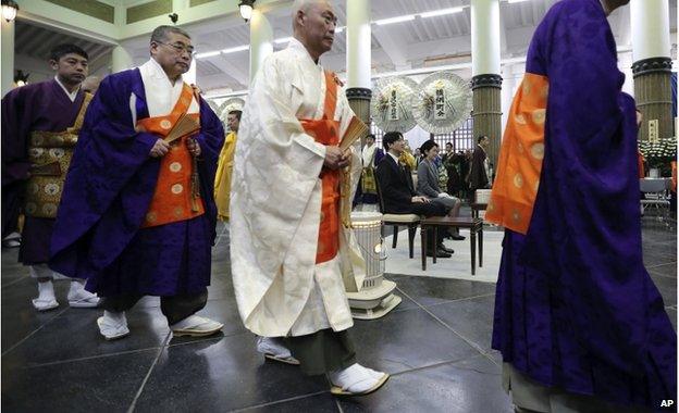 Buddhist priests walk near Japan's Prince Akishino, centre left, and Princess Kiko, centre right, during Tokyo firebombing memorial service in Tokyo Tuesday, 10 March 2015.