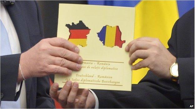 German Foreign Minister Frank-Walter Steinmeier receives a document celebrating 135 years of German-Romanian diplomatic relations