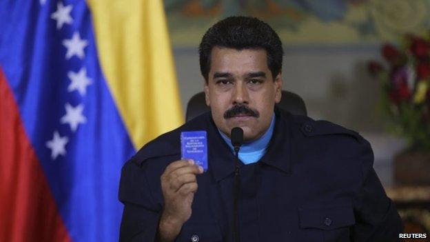 President Nicolas Maduro holds up a copy of the country's constitution as he speaks during a national TV broadcast in Caracas on 9 March 2015