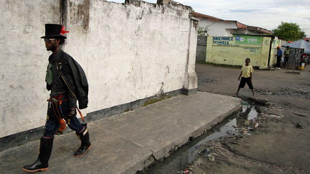 Six Lokoto, leader of the Sapeurs, walks through Kinshasa