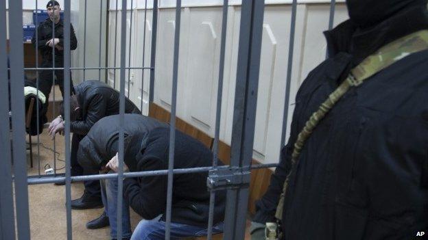 Three men, from the left: Tamerlan Eskerkhanov, Shagid Gubashev and Khamzad Bakhaev suspected of involvement in the killing of Boris Nemtsov sit in a court room in Moscow, Russia, Sunday, March 8, 2015.