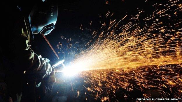 a welder works on a pipe on an oil rig