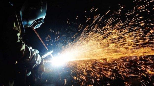 a welder works on a pipe on an oil rig