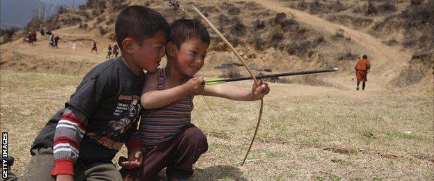 Small boys play with bow and arrow