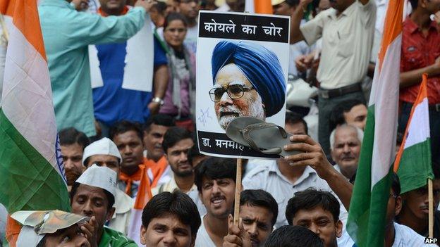 An activist from India Against Corruption (IAC) stamps the picture of Manmohan Singh before marching towards the Prime Minister's residence in Delhi on August 26, 2012