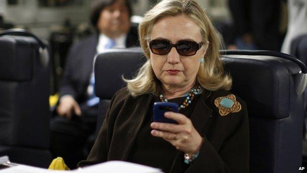 then-Secretary of State Hillary Rodham Clinton checks her Blackberry from a desk inside a C-17 military plane upon her departure from Malta, in the Mediterranean Sea, bound for Tripoli, Libya 18 October 2011