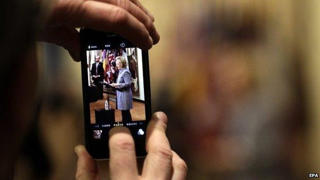 Former United States Secretary of State Hillary Clinton is seen on a smartphone as she speaks to the media in regards to her use of a private email server while serving as Secretary of State 9 March 2015