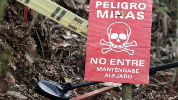 A warning sign is seen as a member of the Humanitarian Demining Battalion of the Columbian Army searches for landmines in Cocorna, Antioquia 3 March 2015