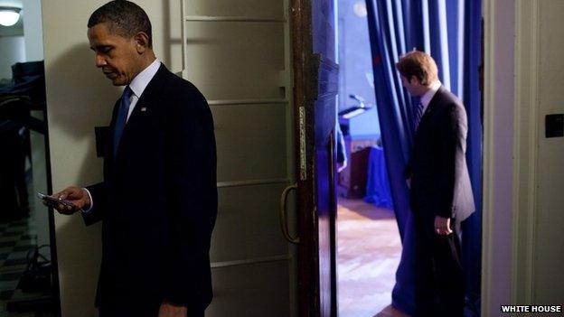 President Barack Obama checks his BlackBerry in a holding room before making remarks on the health insurance reform bill at the Department of Interior, March 23, 2010.