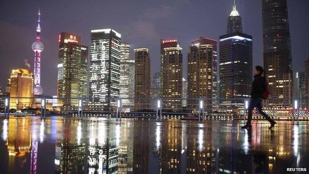 Woman walks at the Bund in front of the financial district of Pudong in Shanghai