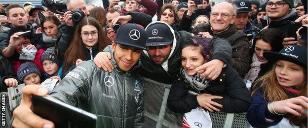 Lewis Hamilton takes a selfie with fans