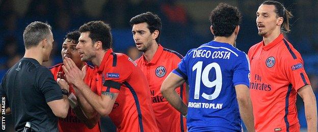 Paris St-Germain players surround referee Bjorn Kuipers