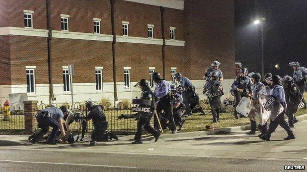 Police officers respond to a fellow officer hit by gunfire outside the Ferguson Police Headquarters in Ferguson, Missouri March 12, 2015
