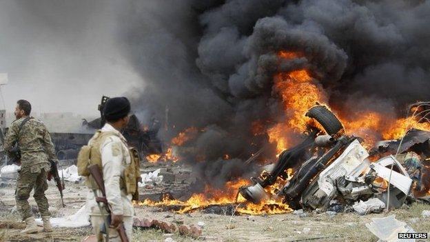 Smoke rises from a car bomb that exploded in a suicide attack on Iraqi government forces by a suspected IS militant on the southern edge of Tikrit (12 March 2015)