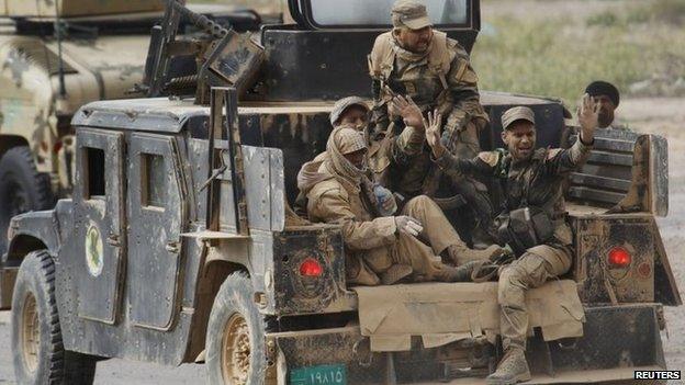 Shia militiaman sit in a Humvee on the outskirts of Tikrit, Iraq (12 March 2015)