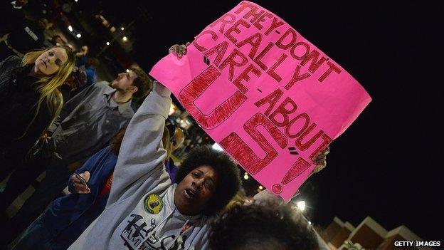 A Ferguson protestor holds up a sign reading: "They don't really care about us".