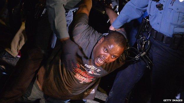 A Ferguson protester is carried away by police.