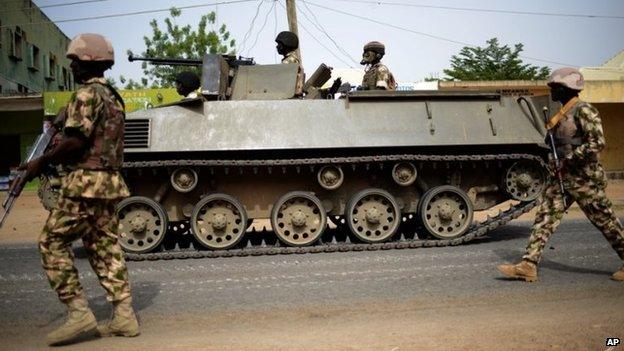 In this photo taken Monday March 9, 2015, Nigerian troops patrol in the north-eastern Nigerian city of Mubi, some 20 kms (14 miles) west of the Cameroon border. Nigerian troops recaptured Mubi from Boko Haram militants in February 2015.