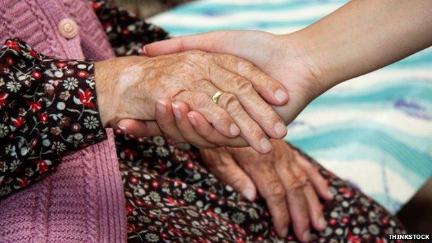 Woman holding an elderly lady's hand