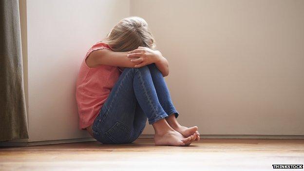 A girl sitting in a corner