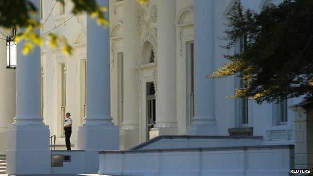 A member of the Secret Service keeps watch at the North Portico entrance to the White House in Washington 22 September 2014