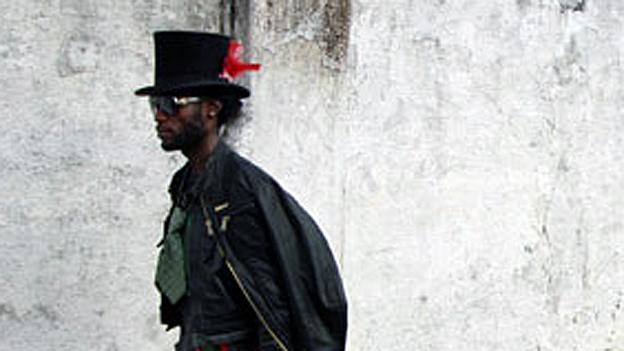 Six Lokoto, leader of the Sapeurs, walks through Kinshasa