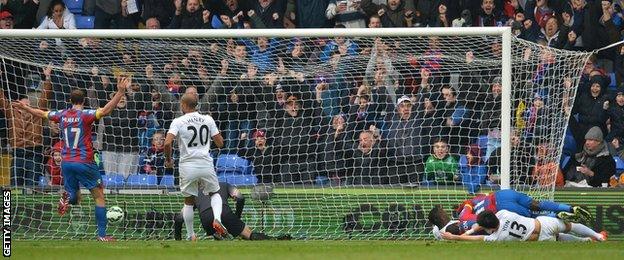 Crystal Palace winger Wilfried Zaha collides with the post on the way to scoring against QPR